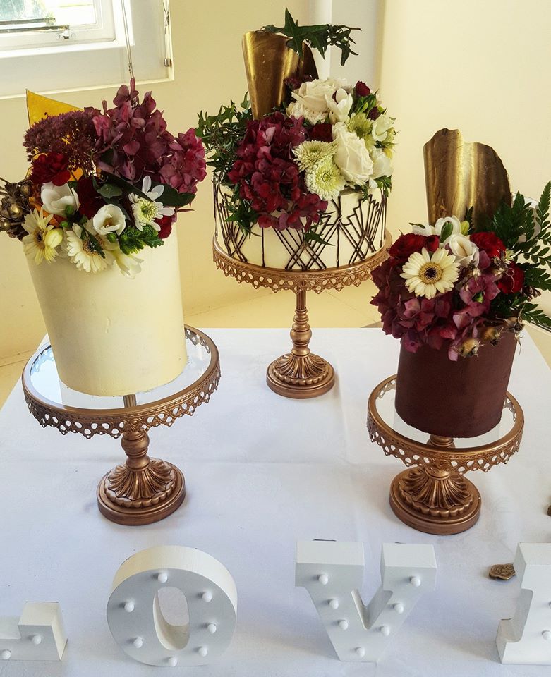 gold, maroon and white trio of wedding cakes